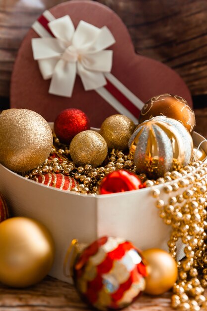 Foto bolas de navidad de colores en una caja en forma de corazón. decoraciones de navidad. año nuevo.