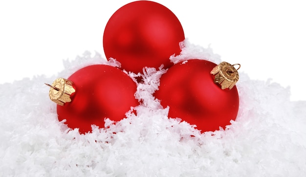 Bolas de Navidad en copos de nieve sobre fondo blanco.