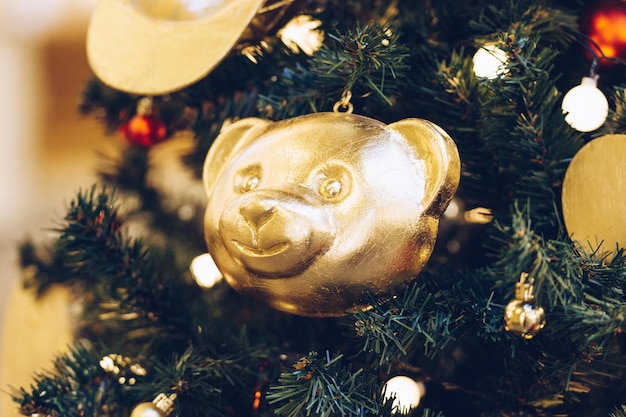 Bolas de Navidad doradas en forma de osos de peluche en el árbol de Navidad