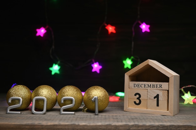 bolas de Navidad doradas y números en 2021, cubos de madera con los números 31 de diciembre