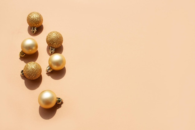 Bolas de Navidad doradas sobre un delicado fondo beige y espacio vacío para texto