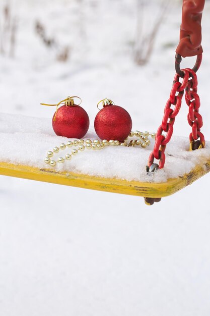 Bolas de Navidad en la nieve en un columpio