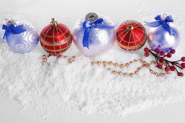 Bolas de Navidad en la nieve con fondo blanco.