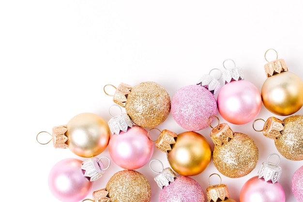 Bolas de Navidad de oro y rosa sobre fondo wite. Endecha plana, vista superior