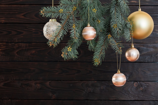 Bolas de Navidad en ramas de abeto sobre fondo de madera oscura.