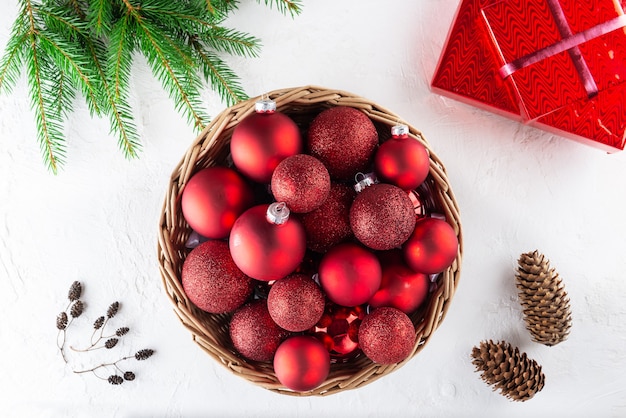 Bolas de Navidad rojas en una canasta sobre un fondo blanco Navidad y año nuevo