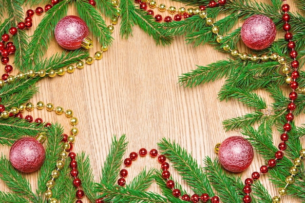 Bolas de Navidad rojas y cuentas con ramas de abeto sobre fondo de madera Espacio de copia