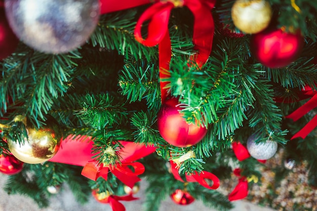 Bolas de Navidad rojas y lazo rojo adornan el árbol de Navidad Fondo de Navidad y bokeh