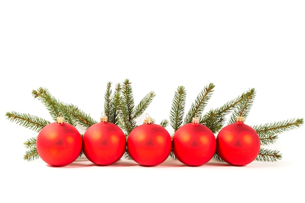 Bolas de Navidad rojas y rama de abeto en blanco.