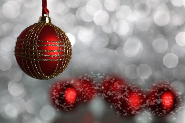 Bolas de Navidad rojas sobre fondo de luces plateadas