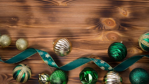 Bolas de Navidad verdes y amarillas sobre un fondo de madera oscura