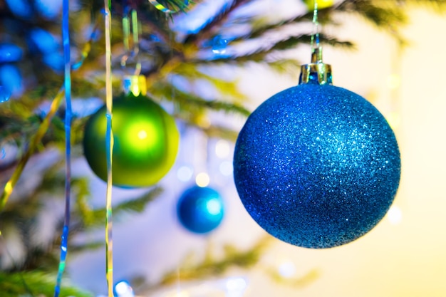 Bolas navideñas azules y verdes con árbol de Navidad sobre fondo amarillo blanco