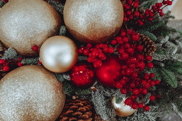 Bolas de oro, frutos rojos y adornos en el árbol de navidad