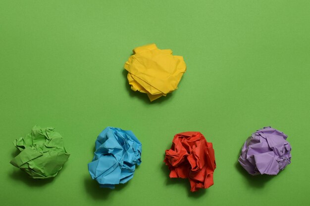Foto las bolas de papel arrugadas de color aisladas sobre un fondo verde copiar el espacio