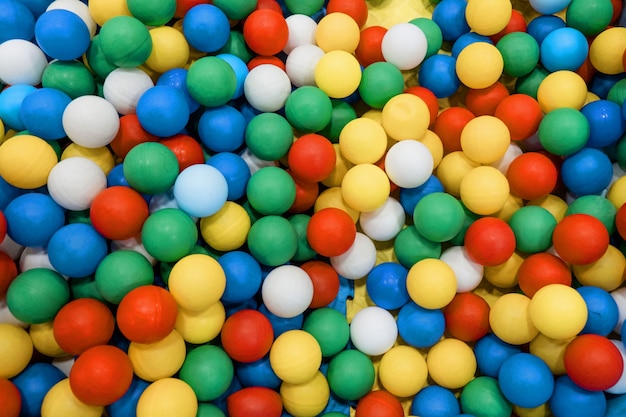 Bolas de plástico de colores en un fondo de sala de juegos para niños