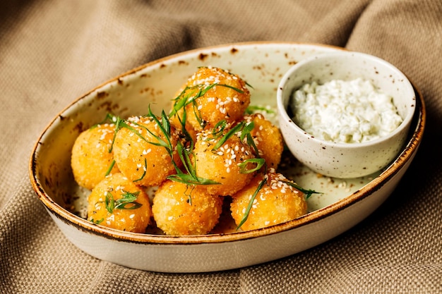 Bolas de queso empanadas con salsa