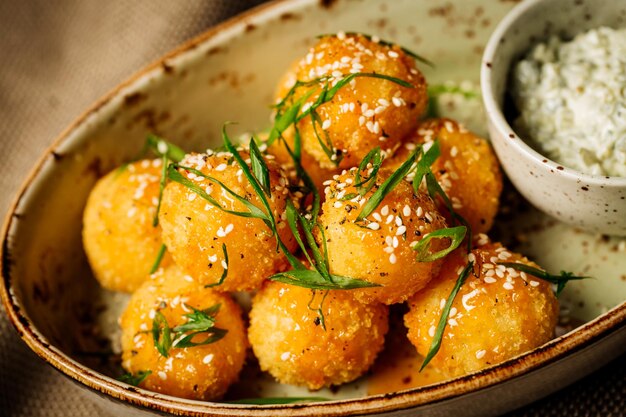 Bolas de queso empanadas con salsa