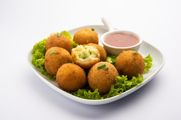 Bolas de queso jalapeño o poppers servidos con salsa de tomate