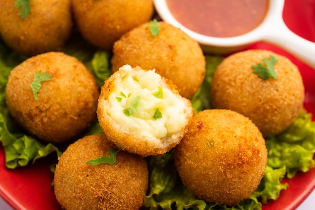 Bolas de queso jalapeño o poppers servidos con salsa de tomate