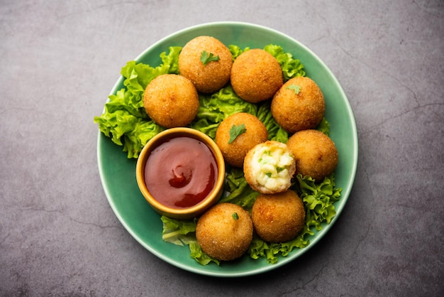 Bolas de queso jalapeño o poppers servidos con salsa de tomate