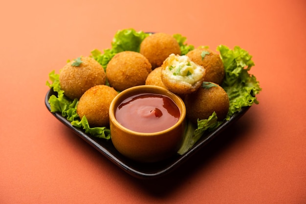 Bolas de queso jalapeño o poppers servidos con salsa de tomate