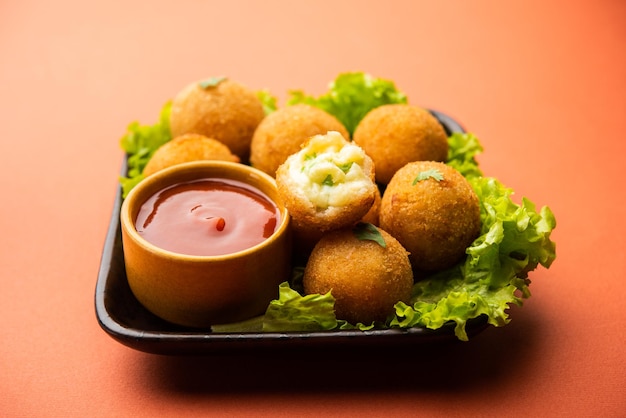 Bolas de queso jalapeño o poppers servidos con salsa de tomate