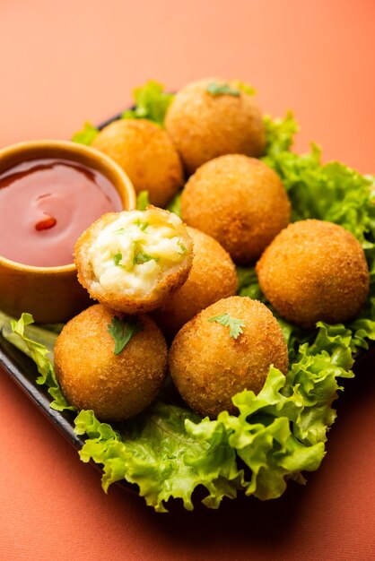 Bolas de queso jalapeño o poppers servidos con salsa de tomate