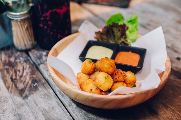 Bolas de queso mozzarella frita servidas con mayonesa y mil islas.