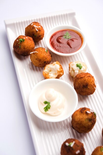 Bolas de queso de patata frita o croquetas con salsa de tomate. Enfoque selectivo