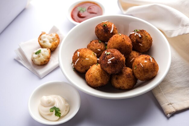 Bolas de queso de patata frita o croquetas con salsa de tomate. Enfoque selectivo