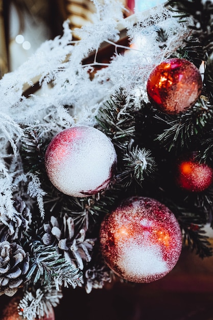 Bolas rojas navideñas cubiertas de nieve