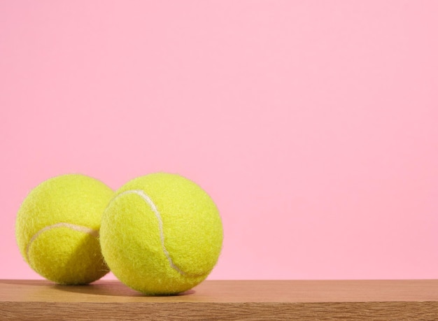 Las bolas de tenis amarillas de colores brillantes se encuentran en una mesa de madera Vida deportiva Copiar espacio para el texto