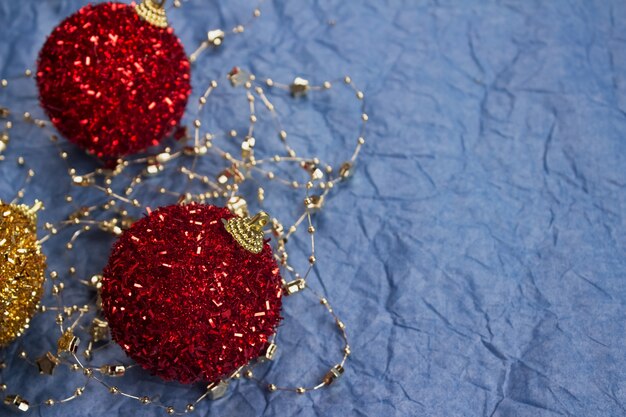 Bolas vermelhas da árvore de natal na mesa azul com copyspace