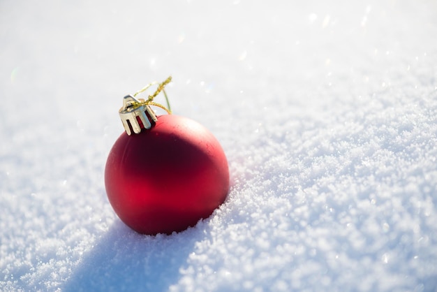 bolas vermelhas de natal com longas sombras na neve fresca no lindo dia ensolarado de inverno