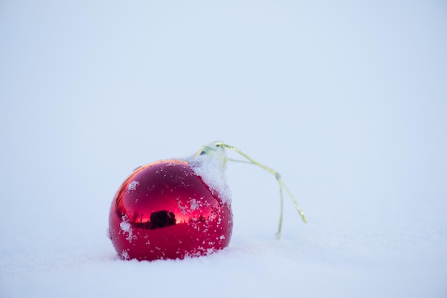 bolas vermelhas de natal com longas sombras na neve fresca no lindo dia ensolarado de inverno