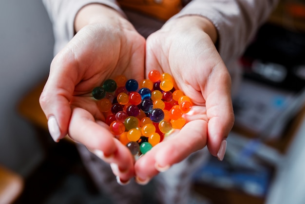 Bolas de vidrio multicolor en sus manos.