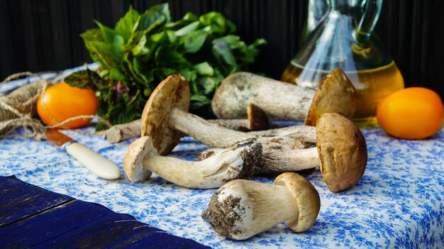 Boletus edulis frescos setas y tomates en la mesa al aire libre en otoño