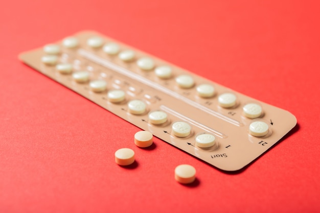 Bolha de pílula contraceptiva em um fundo vermelho