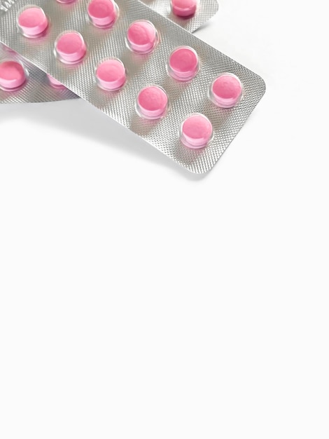 Bolhas com comprimidos cor-de-rosa em uma mesa branca de perto