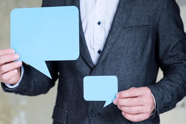 Foto bolhas de fala vazias nas mãos do homem conceito de diálogo de discussão de comunicação de negócios de mídia social