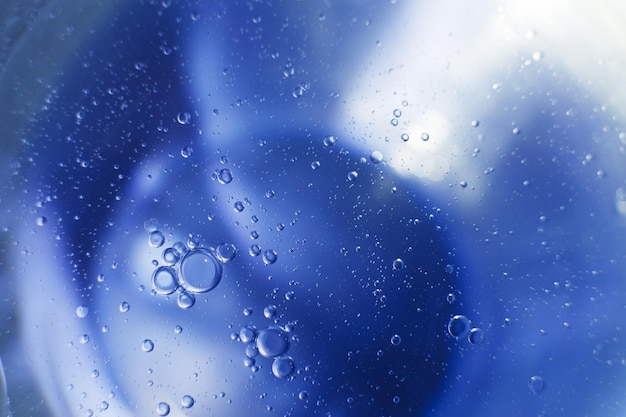 Bolhas de óleo fecham círculos de fundo azul claro macro abstrato de água