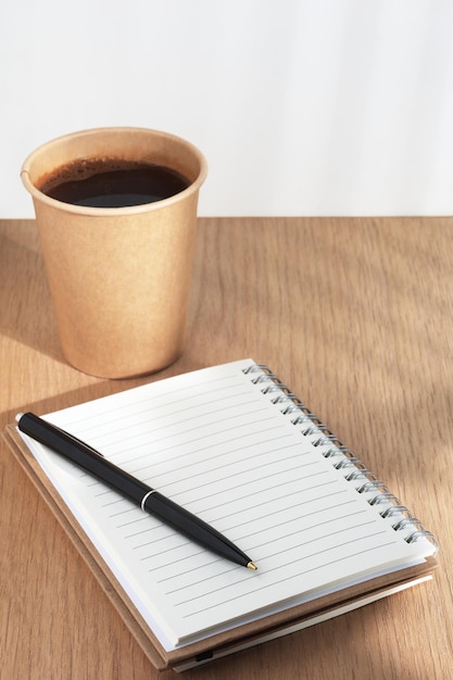 Bolígrafo de cuaderno y taza de café