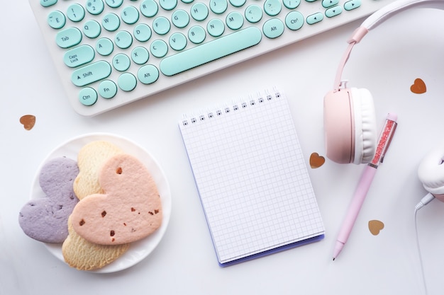 bolígrafo de diseño plano, bloc de notas abierto, plato con galletas de corazón