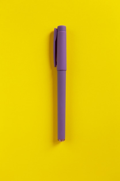 Boligrafo morado sobre papel amarillo