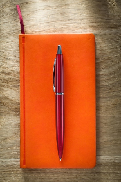 Bolígrafo naranja sobre tablero de madera