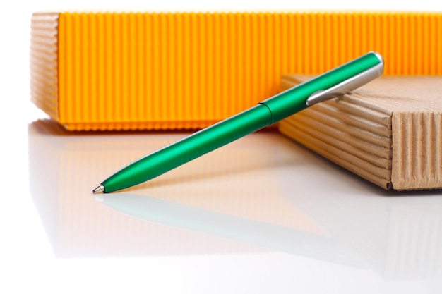 Bolígrafo verde y cuadro de línea amarilla sobre fondos blancos