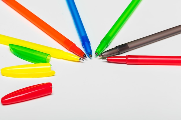 Foto bolígrafos de diferentes colores aislados en el blanco