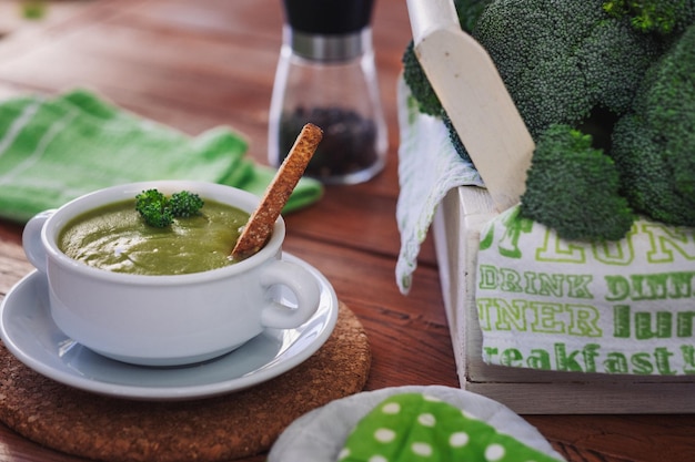 Bolinha com sopa de brócolis feita à mão e croutons de brôcolis verde cru fresco em mesa de madeira