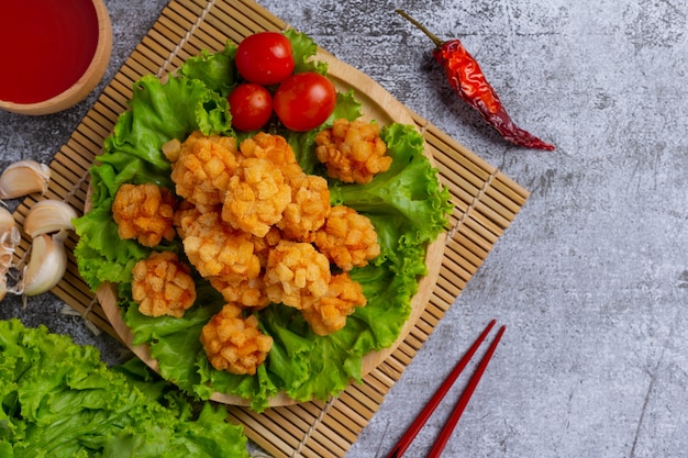 Bolinhas de camarão cobertas com à milanesa frita na superfície escura.