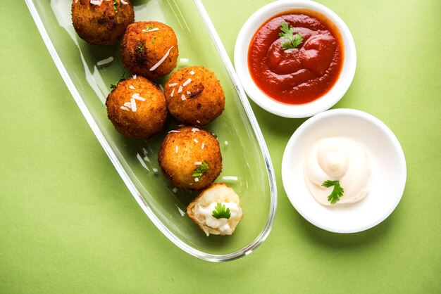 Bolinhas de queijo de batata frita ou croquetes com ketchup de tomate. Foco seletivo